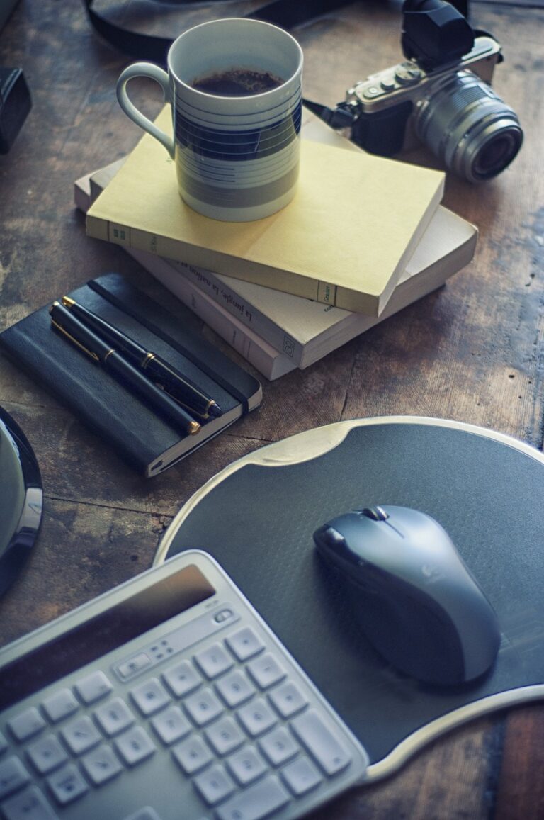 Bureau avec tasse, souris, clavier, appareil photo et carnets