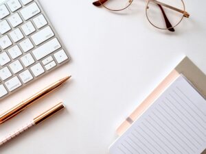 Bureau épuré avec clavier, lunettes, stylos et bloc